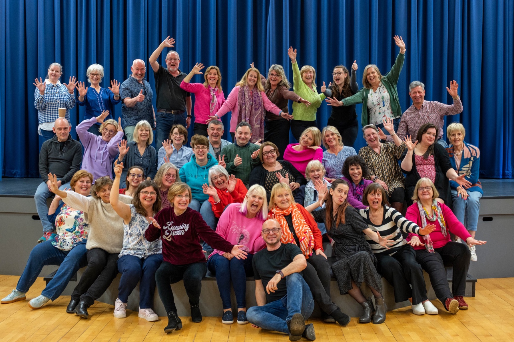 Next Stage Choir members smiling, waving and having fun together